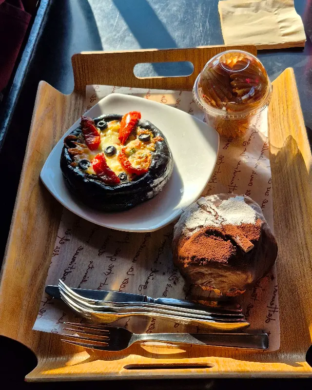 검은색 빵 위에 빨간 토핑이 올려져 있는 빵과 밤으로 보이는 재료가 들어간 빵