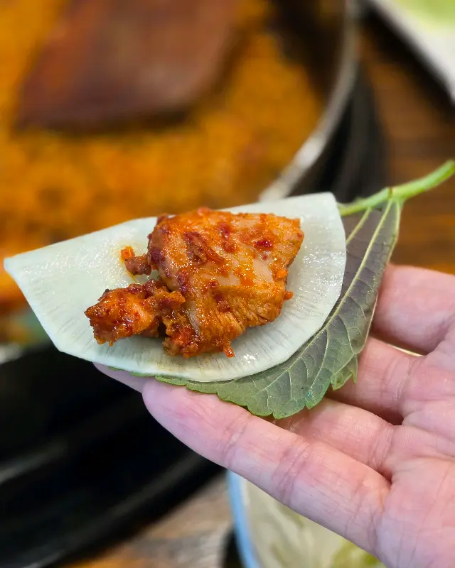 닭갈비를 깻잎에 싸서 먹는 모습