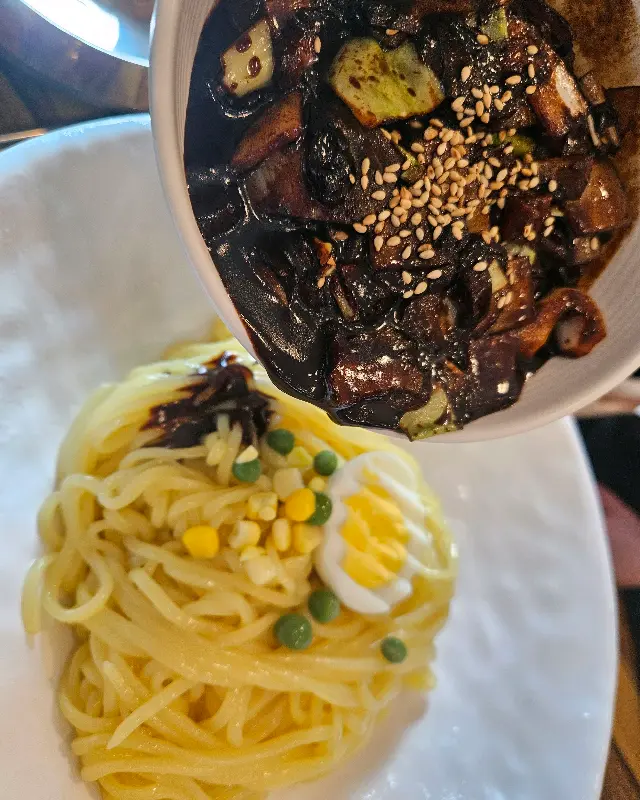 간짜장 소스를 면에 붓는 모습