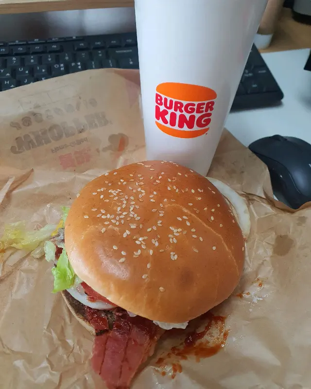 종이 포장지에 싸여있는 햄버거와 콜라