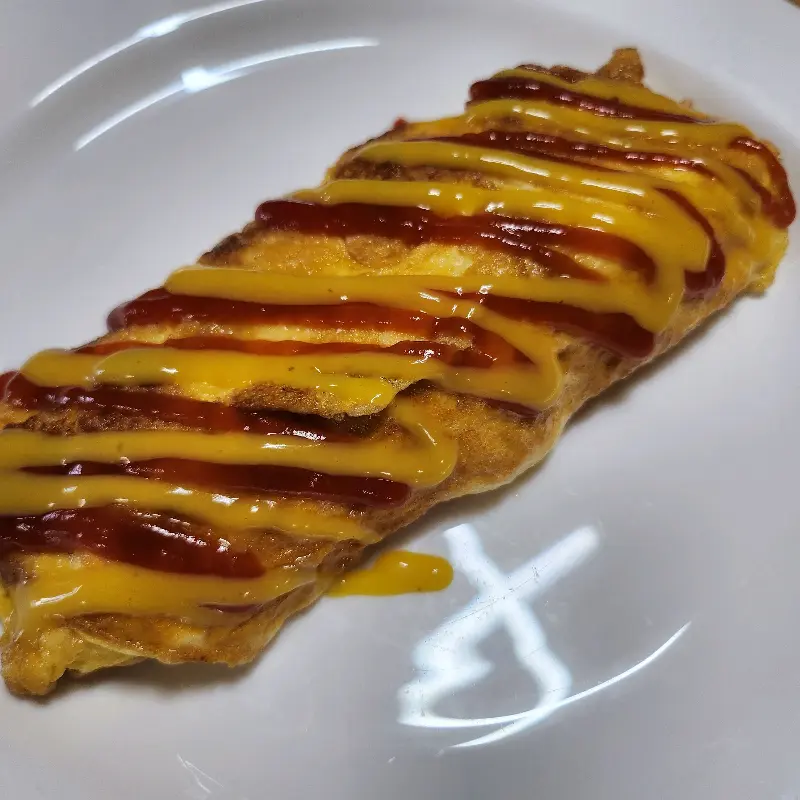 케첩과 머스타드 소스가 뿌려진 계란말이