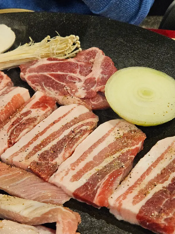 솥뚜껑에 구워지는 삼겹살, 버섯, 양파