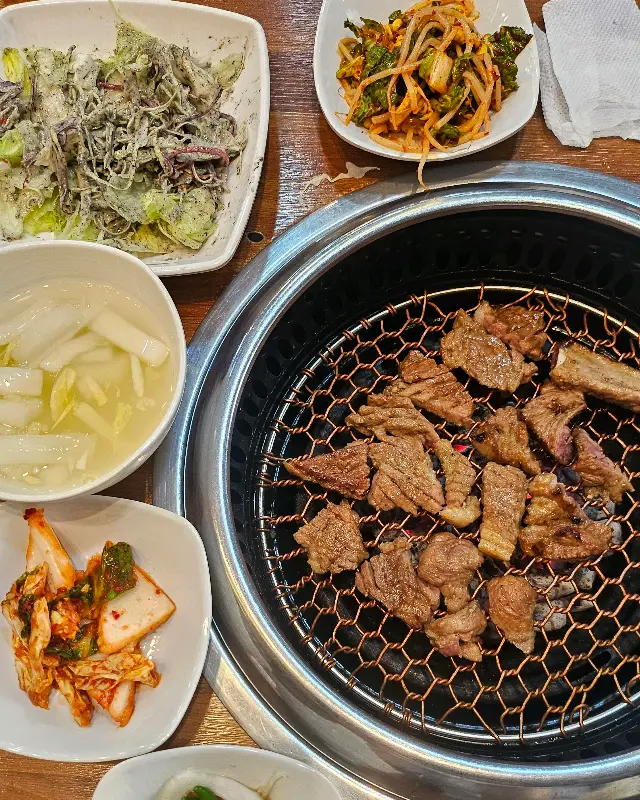 숯불에 구워진 돼지갈비와 풍성한 밑반찬
