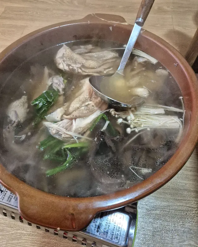 국자로 오리 백숙을 뜨는 모습