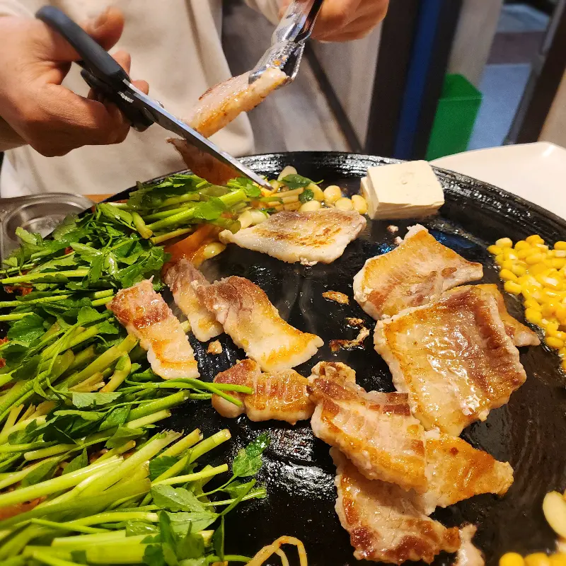 미나리, 콩나물, 김치와 함께 구워진 삼겹살