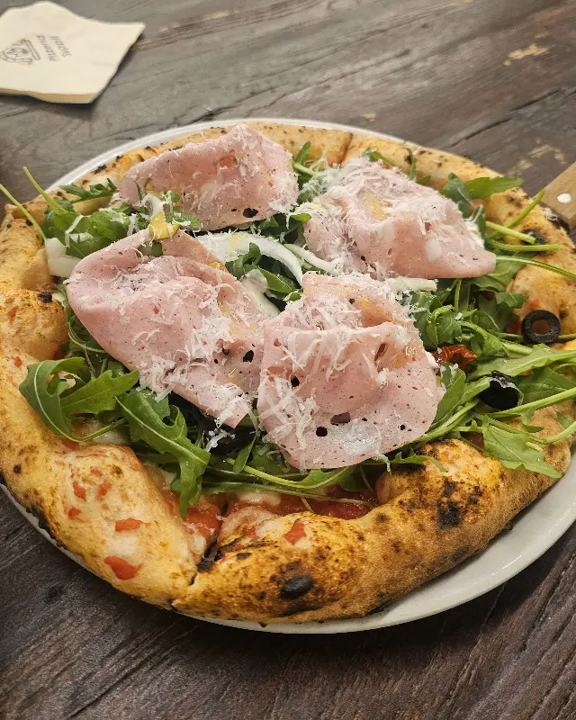 프로슈토와 루꼴라가 조화롭게 토핑된 피자