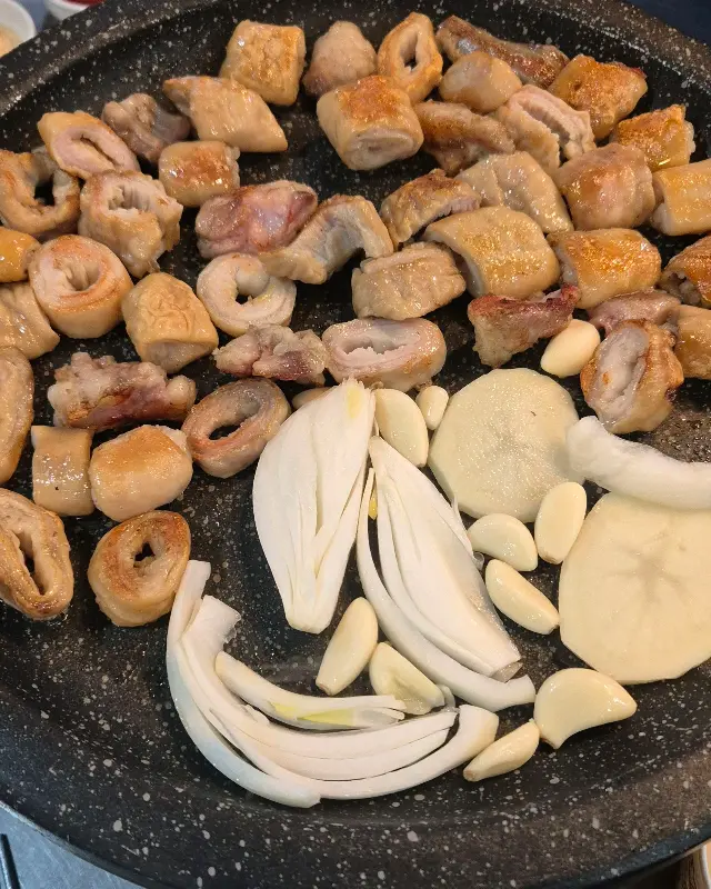 불판 위에 익어가는 막창과 양파, 마늘