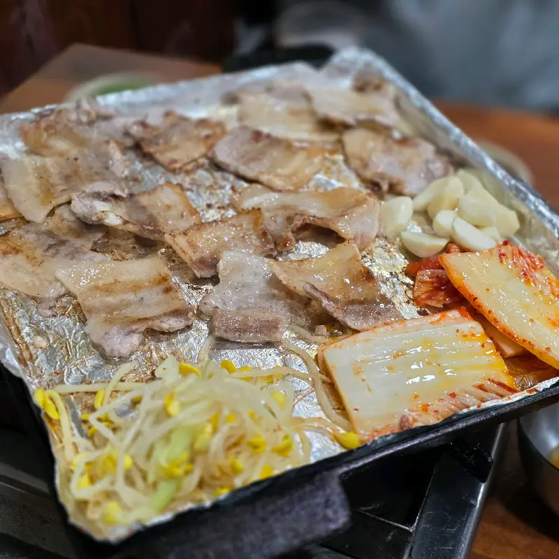 불판 위 삼겹살, 김치, 콩나물