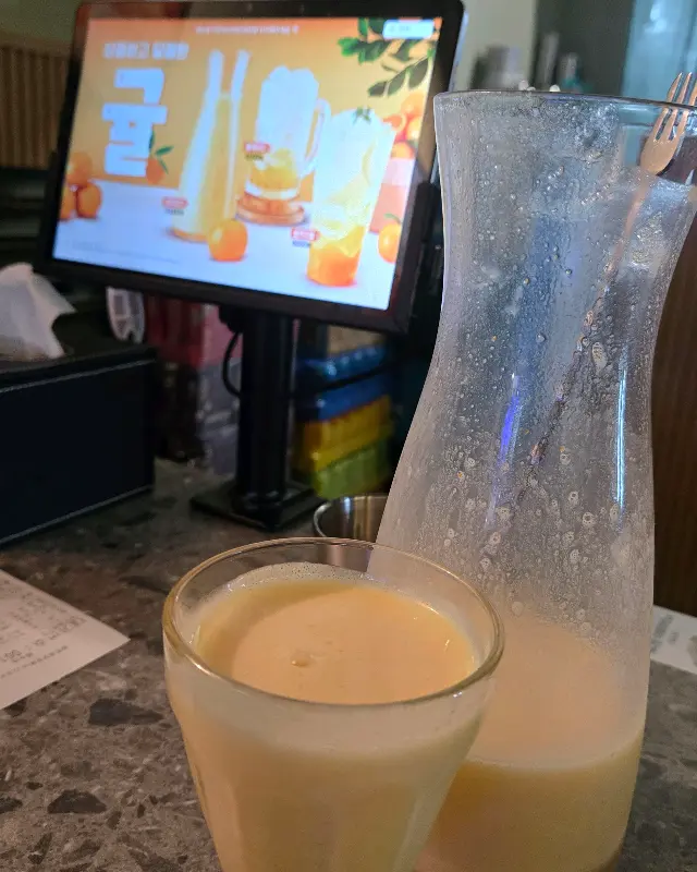 귤 막걸리가 담긴 유리잔과 주전자