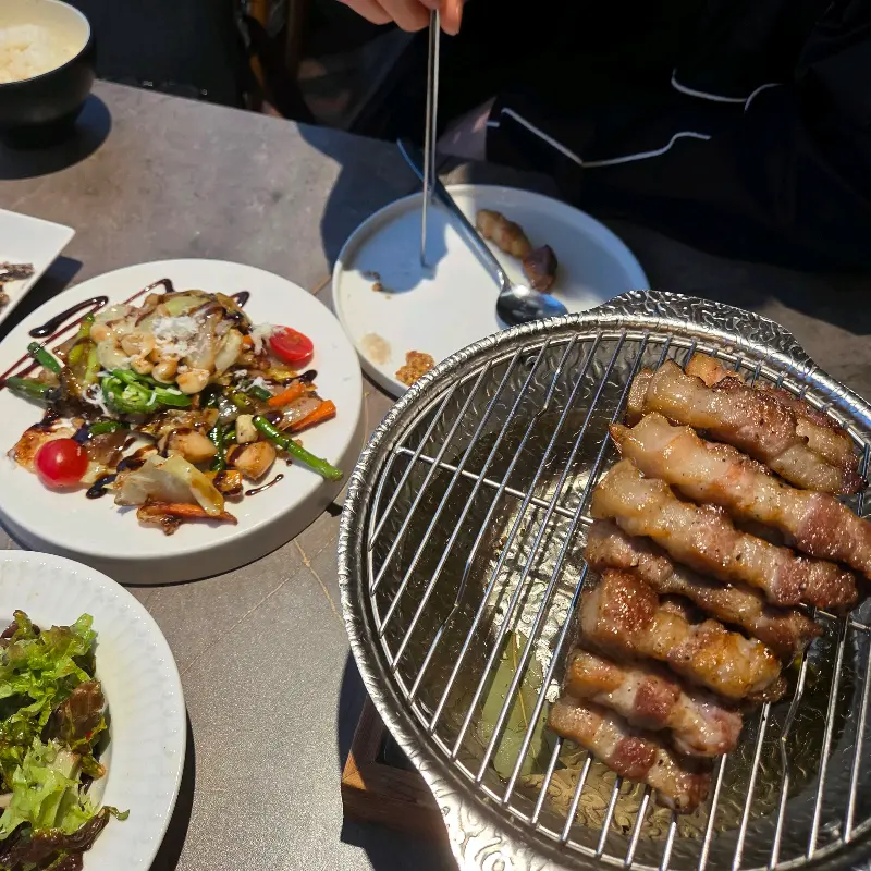 노릇하게 구워진 삼겹살이 석쇠 위에 가지런히 놓여 있다.