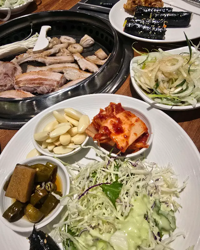 다채로운 곁들임과 함께 구워진 고기