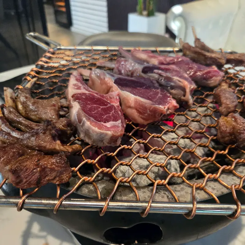 숯불 위에서 익어가는 프렌치 랙과 숄더 랙