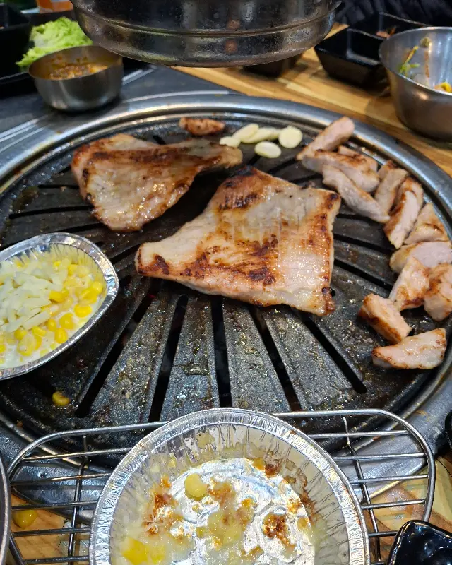 불판 위에서 노릇하게 익어가는 삼겹살 사진