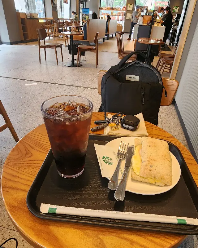 아이스 아메리카노와 햄 루꼴라 파니니가 놓인 쟁반