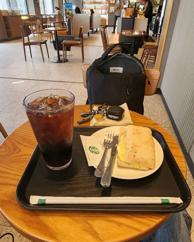 테이블 위에 놓인 콜드브루와 파니니