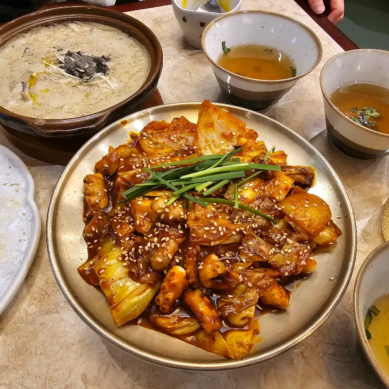 낙지볶음, 들깨탕, 밥, 샐러드 등이 테이블에 차려진 모습