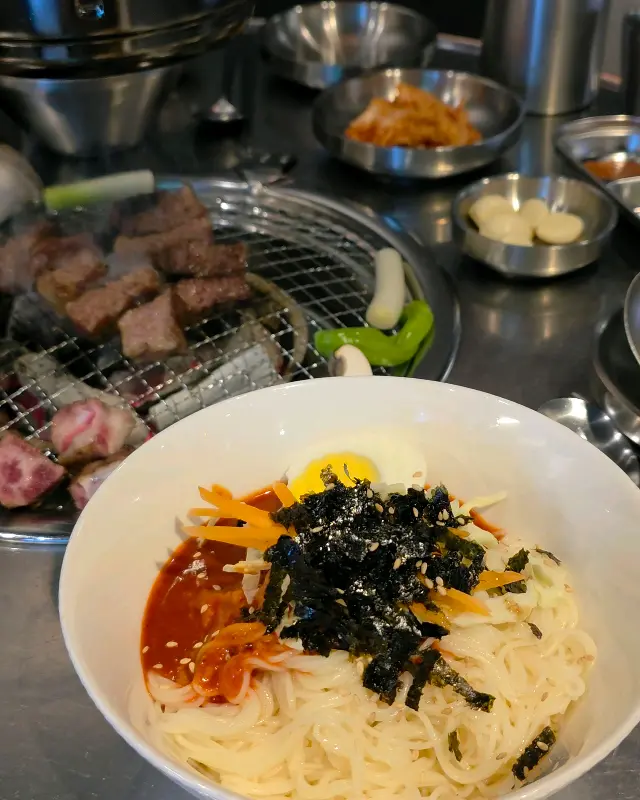숯불 위에 구워지는 생갈비살과 비빔국수