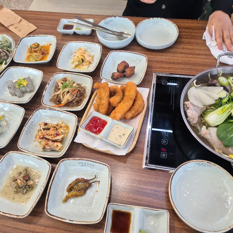 다양한 반찬과 튀김, 아구탕이 놓인 테이블