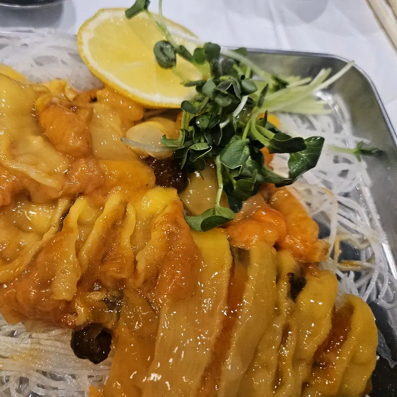 레몬과 새싹으로 장식된 미더덕회 한 접시