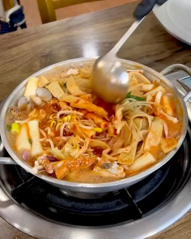 국자로 떡볶이를 뜨는 모습