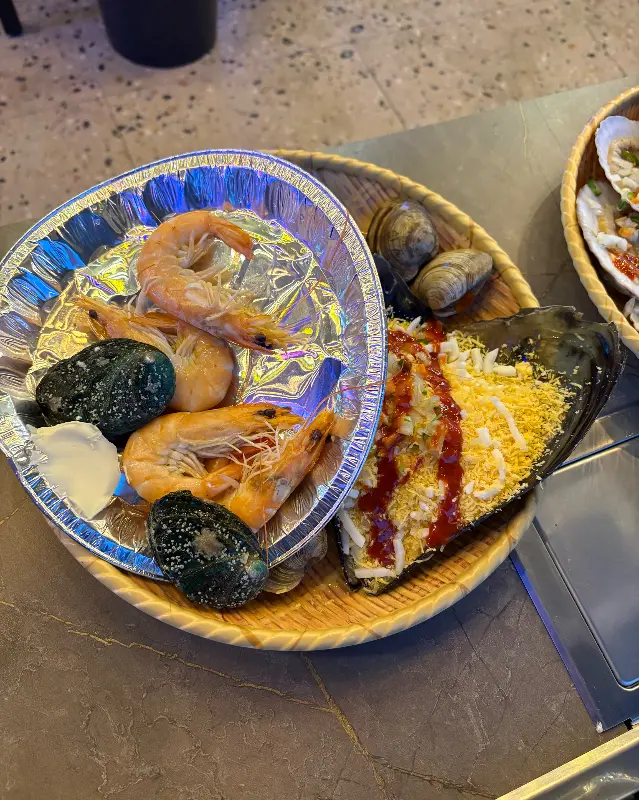 다양한 해산물과 곁들임 메뉴가 조화로운 조개구이