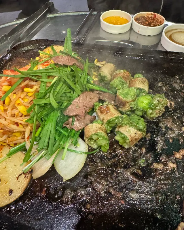 돌판 위에 곱창, 염통, 김치, 콩나물 등이 함께 구워지고 있는 모습