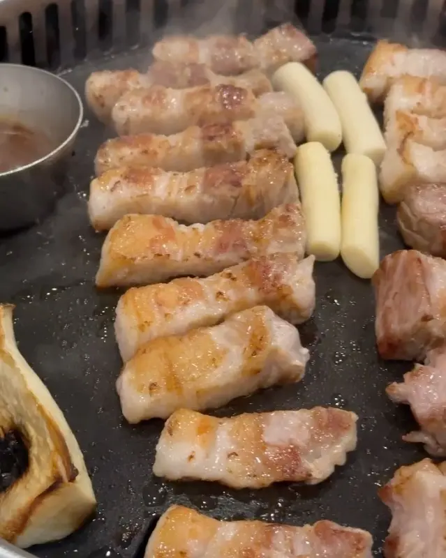 노릇하게 구워진 삼겹살과 떡의 모습