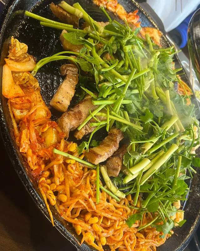 불판 가득한 삼겹살과 미나리