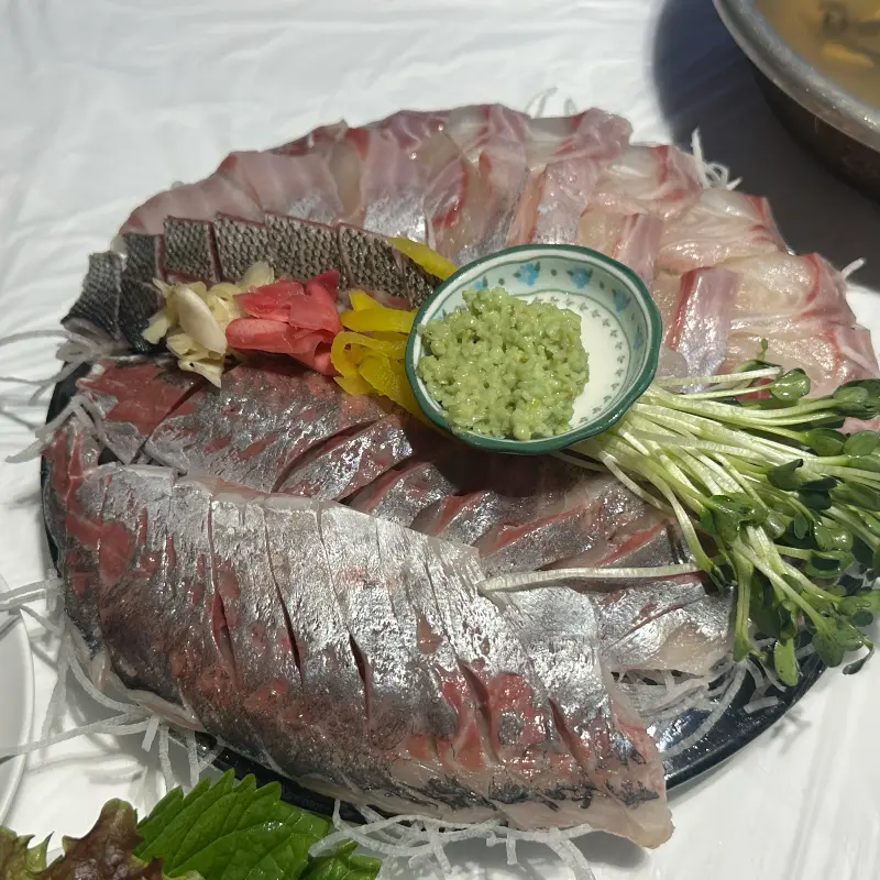 신선한 회 한 접시, 와사비와 새싹이 곁들여져 있다.