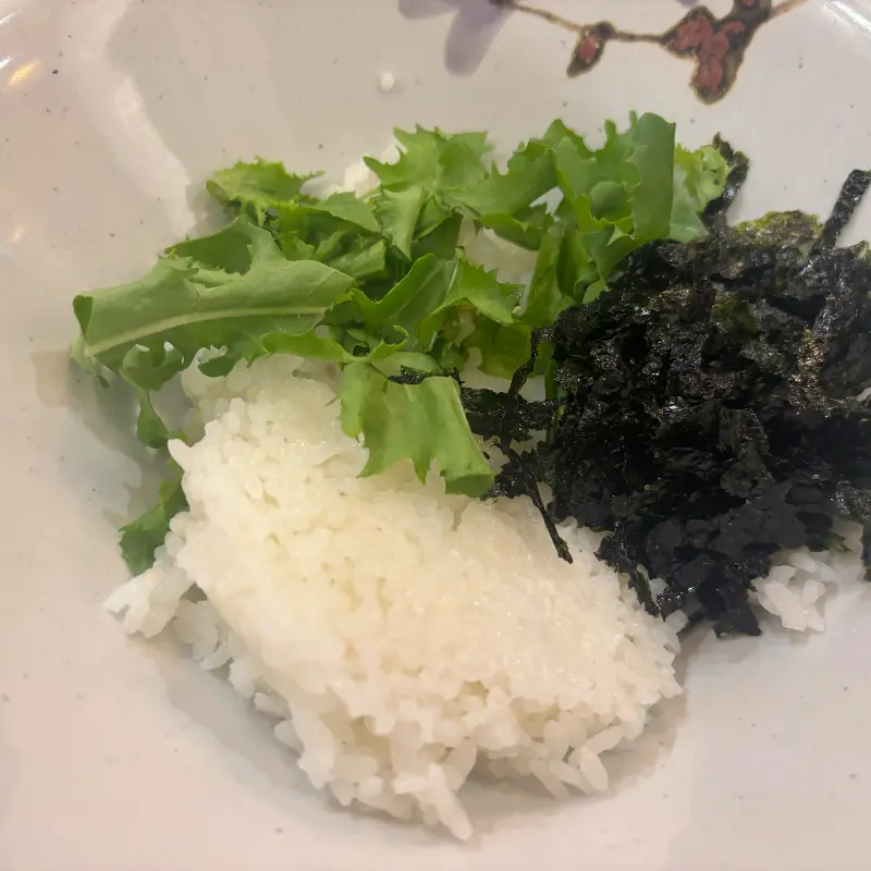 밥에 샐러드와 김가루가 올려져 있는 모습