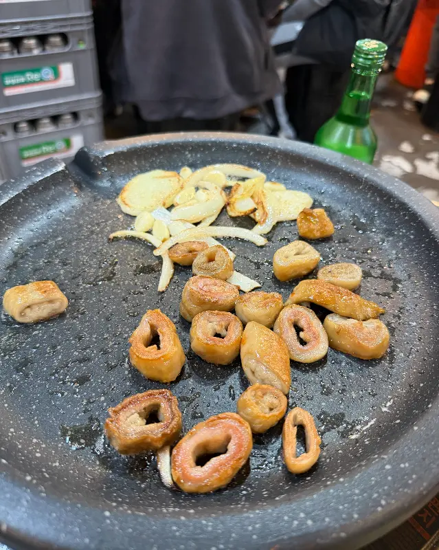 불판 위에 익어가는 막창, 양파, 마늘