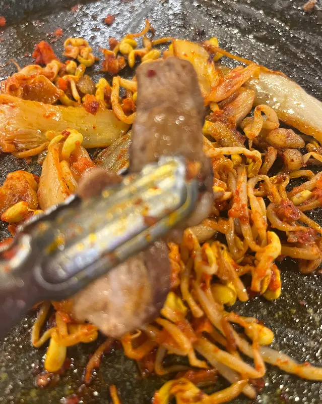 삼겹살 기름에 구워진 김치와 콩나물