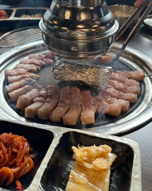 육풍 평택역점 불판 위에서 가지런히 구워지고 있는 삼겹살 사진