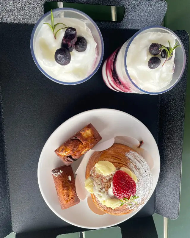 테이블 위에 놓인 디저트. 요거트와 빵이 보인다.