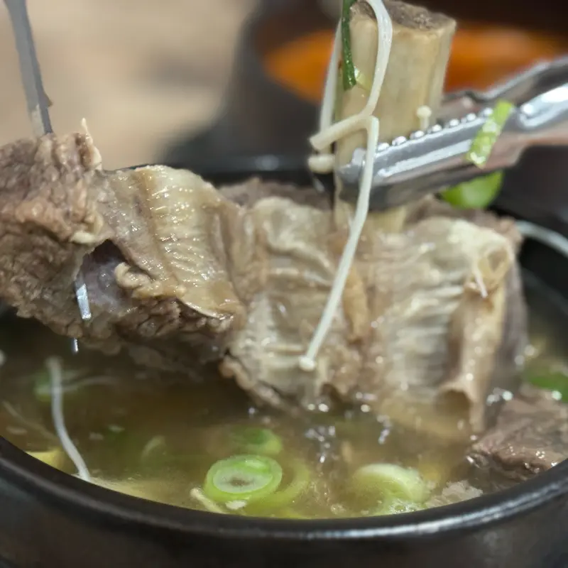 갈빗대에 붙은 살코기를 집게로 들어올리는 모습