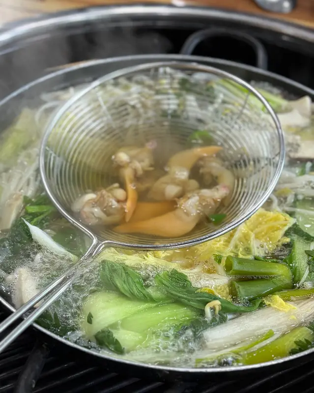 갈미조개 샤브샤브를 먹기 위해 조개를 국자로 건져올리는 모습