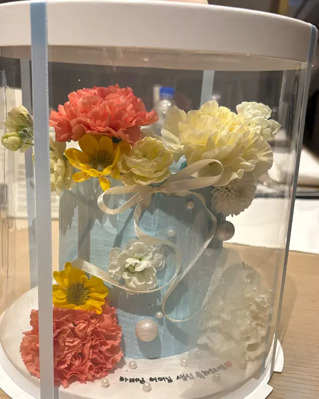 투명 케이스에 담긴 아름다운 생화 케이크