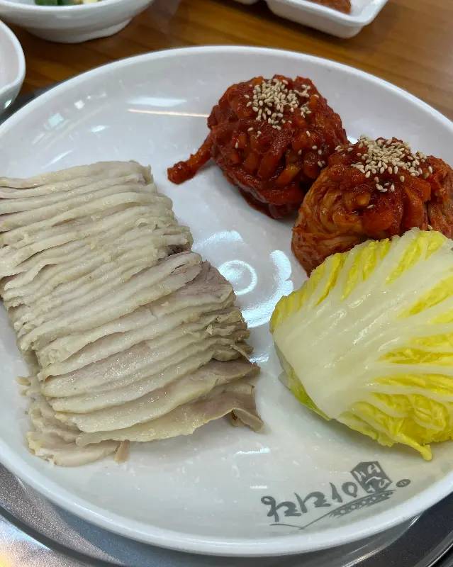 얇게 썰린 보쌈과 매콤한 김치가 함께 담겨 나온 모습