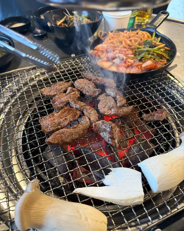 숯불 위에서 익어가는 소갈비살과 김치