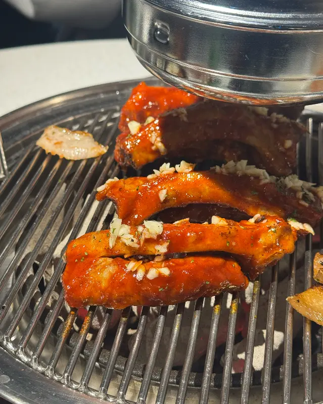 매콤한 양념이 잘 발린 쪽갈비가 석쇠 위에서 맛있게 구워지고 있는 모습