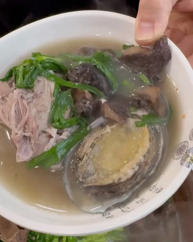 능이, 전복, 오리고기가 푸짐하게 담긴 국물 한 숟가락