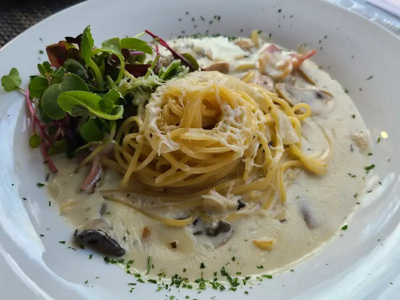 크림 파스타 위로 잎채소가 얹어진 모습