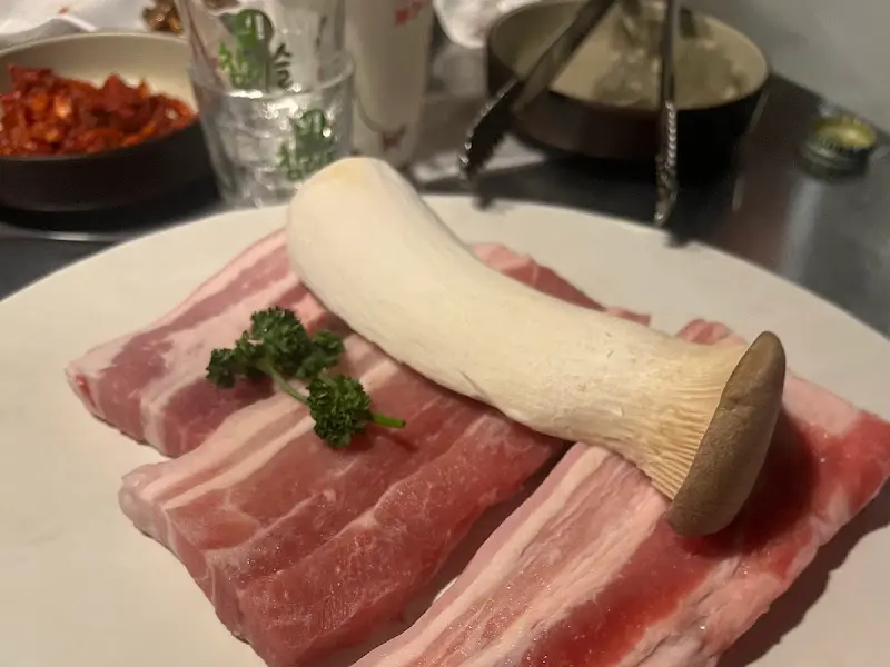 잘 구워진 삼겹살과 곁들임 채소, 버섯