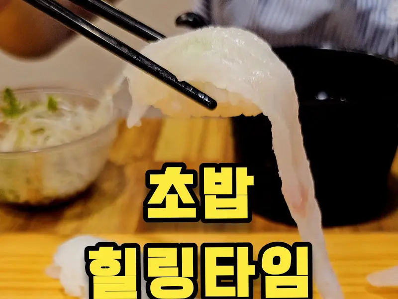 젓가락으로 흰 살 생선 초밥을 들어 올리는 모습