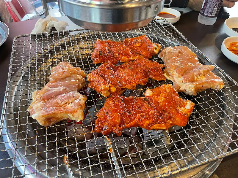 숯불 위에 올려진 양념 닭갈비와 간장 닭갈비