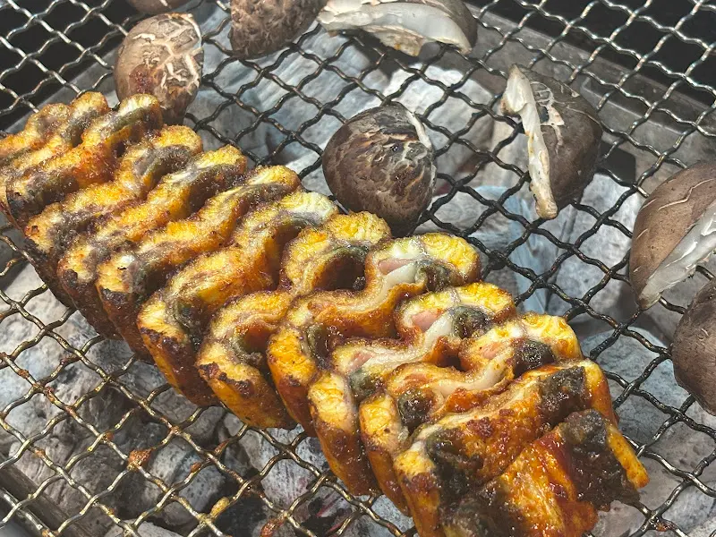 숯불 위에서 구워지는 장어와 버섯