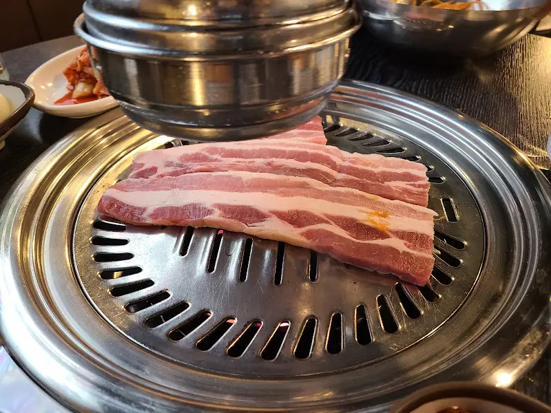 불판 위에 올려진 두툼한 생삼겹살