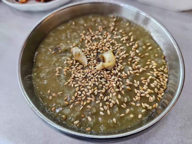 전복죽 위에 깨가 듬뿍 뿌려져 있는 모습