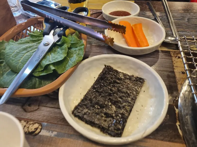 싱싱한 쌈 채소와 구운 김, 곁들임 채소들이 풍성하게 제공된다.