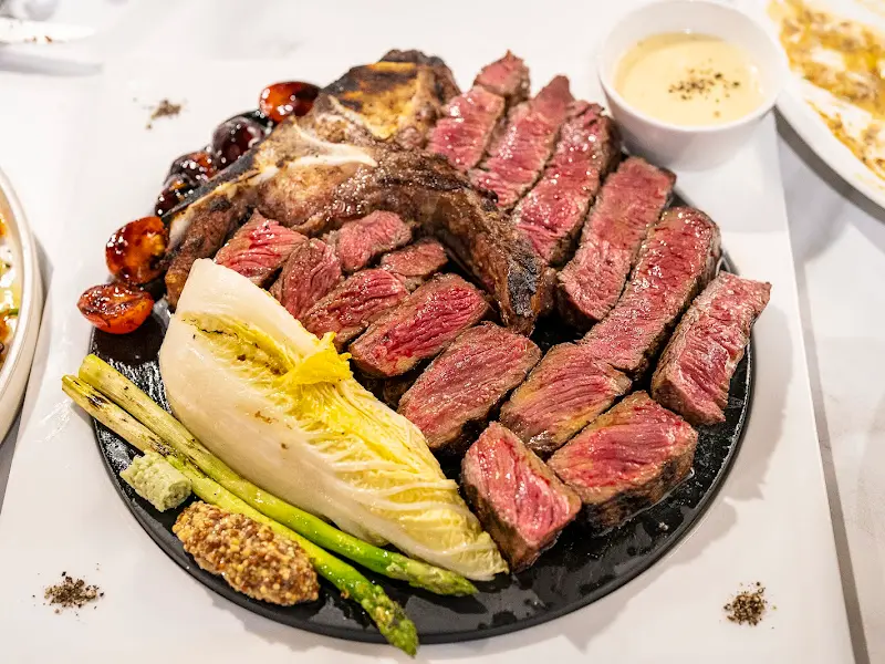 블랙 플레이트 위에 육즙 좔좔 흐르는 티본 스테이크